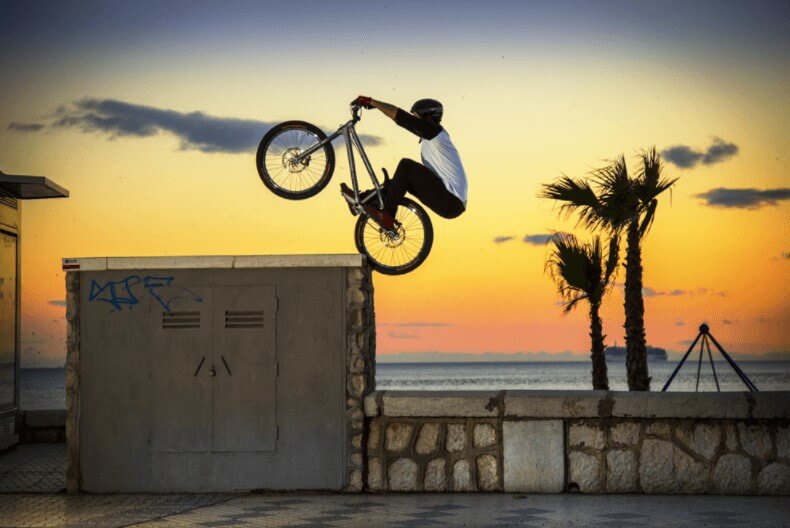 Trials rider hopping up to a ledge on the back wheel