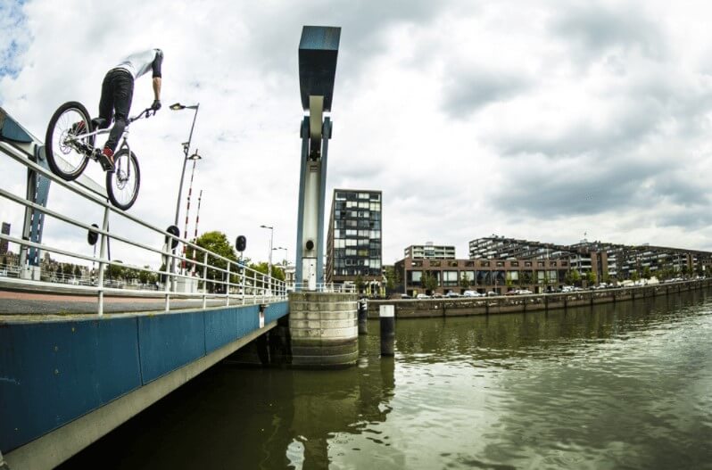 Street trials balancing on a handrail crossing a bridge